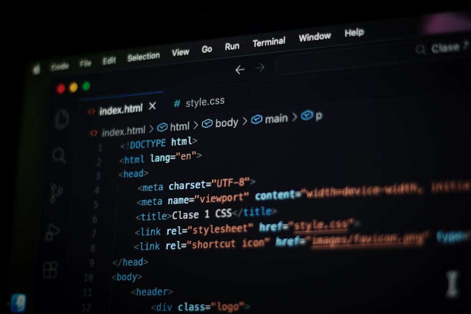 A close-up view of a laptop computer on a desk displaying code in a text editor alongside a calculator application with orange buttons showing numerical and operational functions. The laptop has a whi